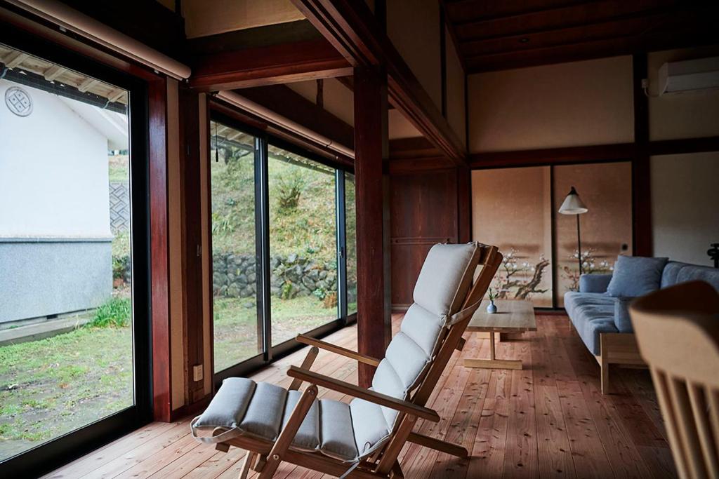 salon z krzesłem i kanapą w obiekcie wine& stay Shinyashiki w mieście Nishimura
