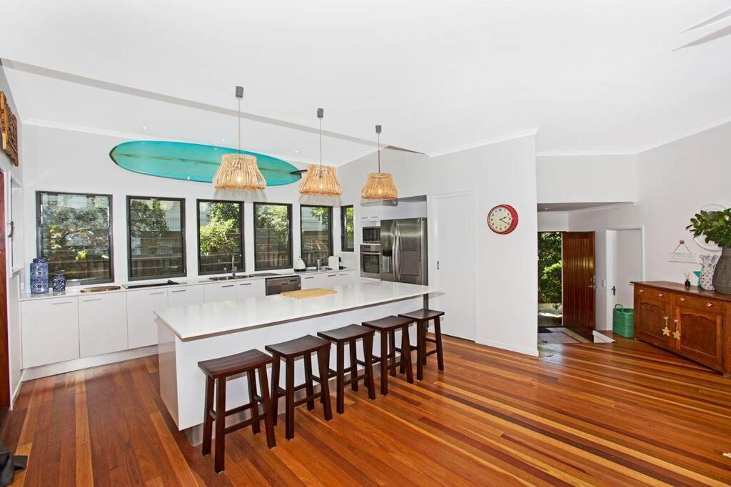 une cuisine avec un bar avec des tabourets et un comptoir dans l'établissement Casuarina Cabana Beach House, à Casuarina
