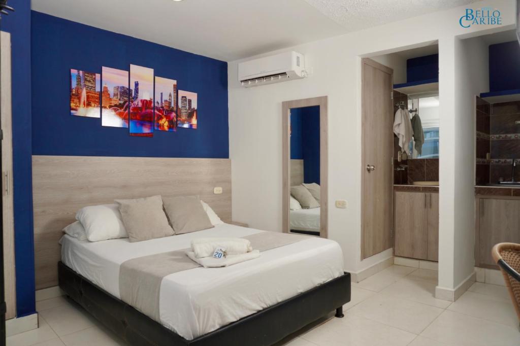 um quarto com uma cama grande e uma parede azul em Hotel Bello Caribe em Santa Marta