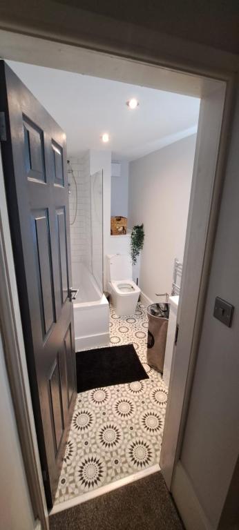 uma casa de banho com uma banheira, um WC e uma porta em MARSH lux 2 em Manchester