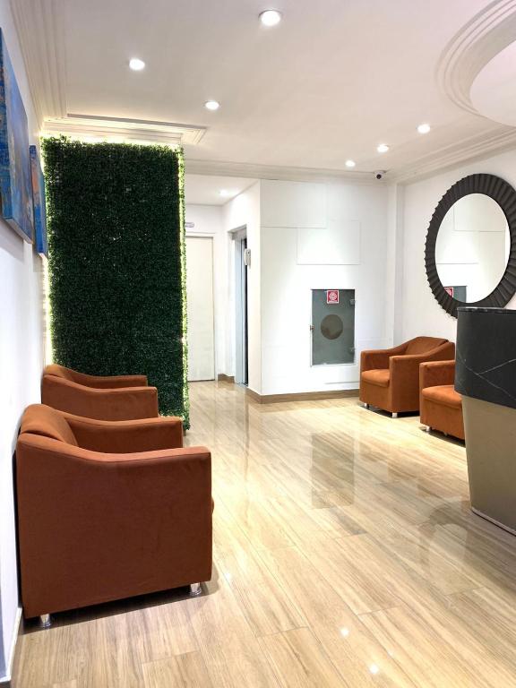 a lobby with chairs and a green wall at Lory Studio Hotel in São Paulo