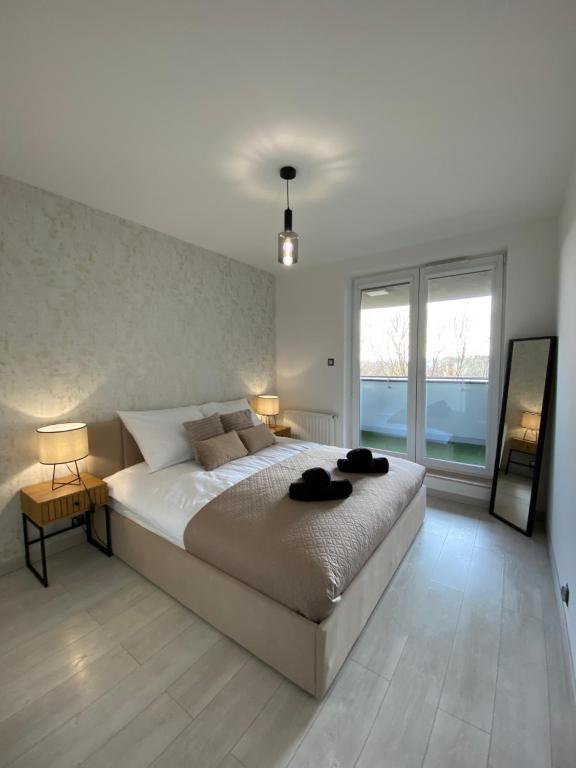a bedroom with a large bed with two lamps on it at ST TOWER Apartament in Rzeszów