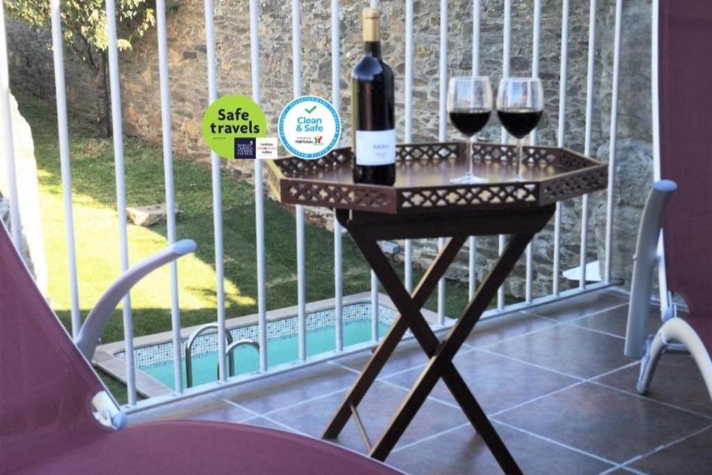 stół z dwoma kieliszkami wina na balkonie w obiekcie Sobreiro's Villa in Douro Valley w mieście Mesão Frio