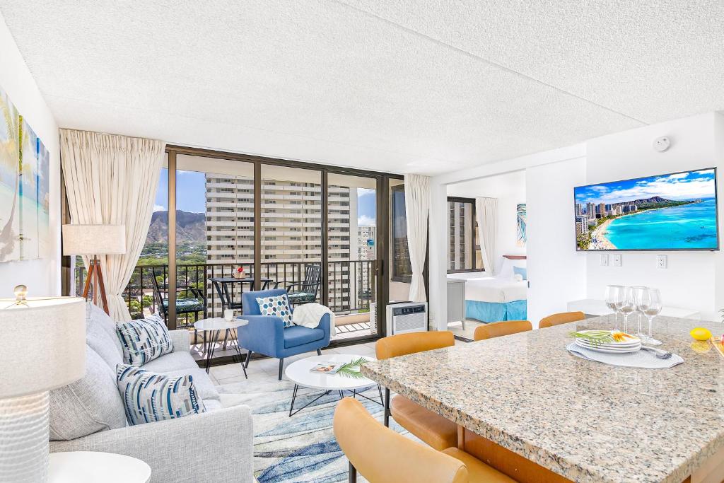 a living room with a table and chairs and a couch at Waikiki Banyan 15FL - views, pool & hot tub access in Honolulu