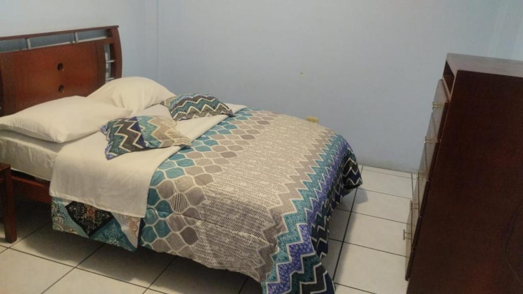 a bedroom with a bed with a quilt and pillows at Hostal Maria José in Baños