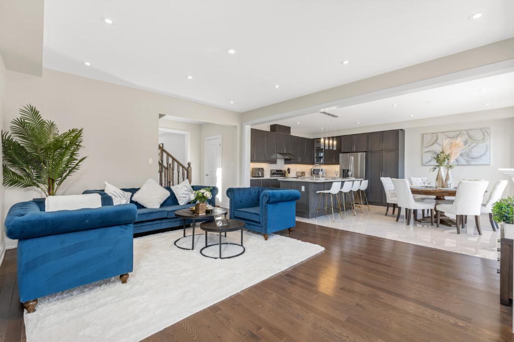 uma sala de estar com sofás azuis e uma cozinha em Executive 5BR-4BATH Detached Bramp/Miss Border em Brampton