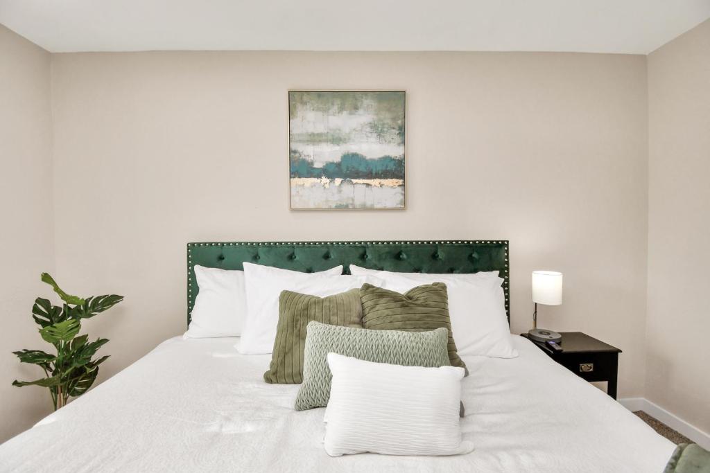 1 dormitorio con cama blanca y cabecero verde en The Dewberry, en Houston