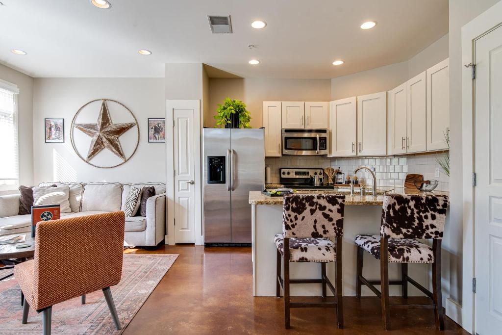 a kitchen with white cabinets and a kitchen island with chairs at The Celebrity - Minutes to Broadway with a Balcony in Nashville