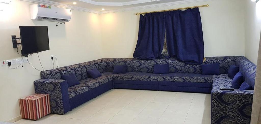 منتجع السالم بالهدا في الهدا: أريكة زرقاء في غرفة المعيشة مع تلفزيون