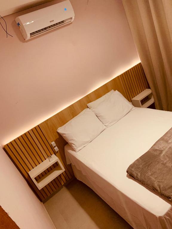 ein kleines Schlafzimmer mit einem Bett und einer Klimaanlage in der Unterkunft Sol de Corumbau in Corumbau