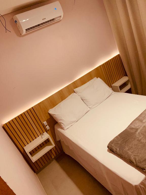 ein kleines Schlafzimmer mit einem Bett und einer Klimaanlage in der Unterkunft Sol de Corumbau in Corumbau