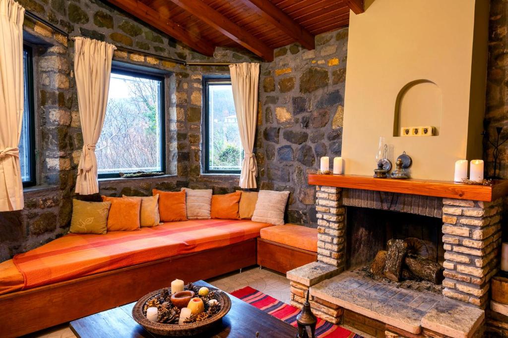 a living room with a couch and a fireplace at Marianda's House - Mountain Views & Rustic Charm in Tíkhion