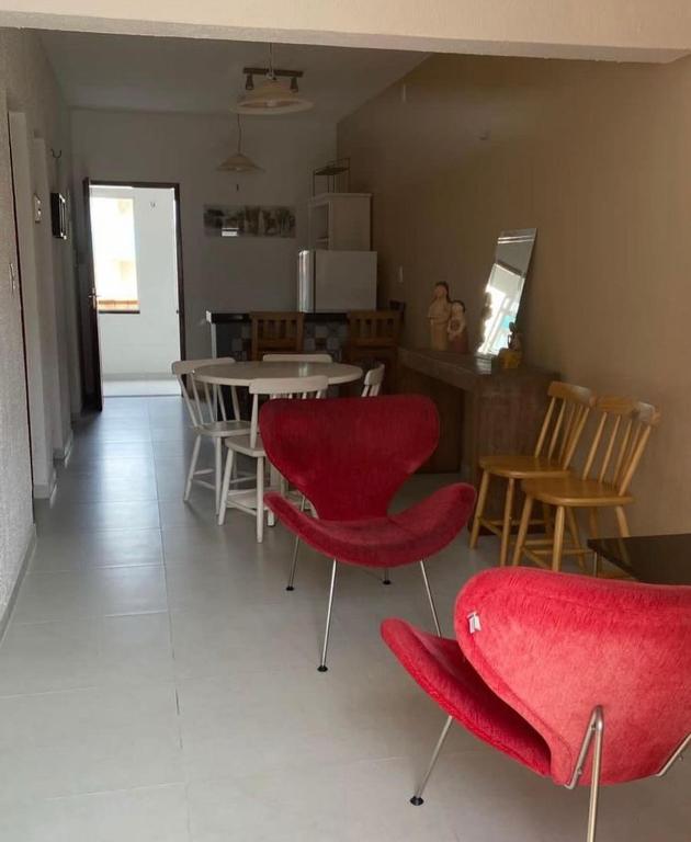 sala de estar con sillas rojas y mesa en Casa Aconchego Guaramiranga, en Guaramiranga