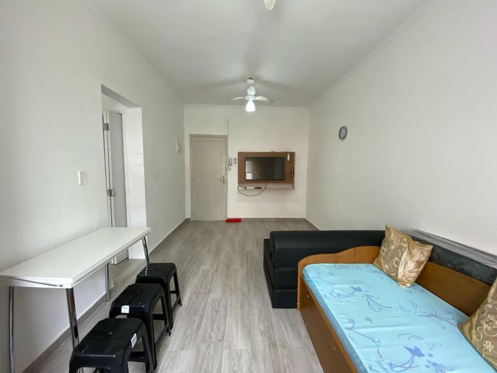 a living room with a couch and a table at Kitnet aconchegante no centro, a poucos passos da praia in Praia Grande