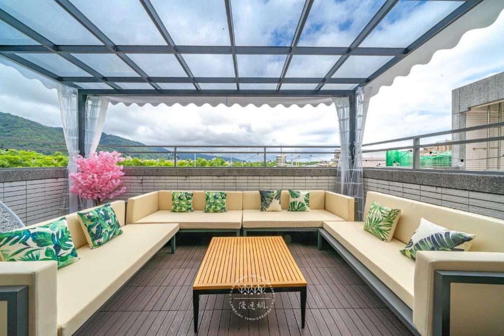 un patio con sofás y una mesa en el techo en 田園走走 en Jiaoxi