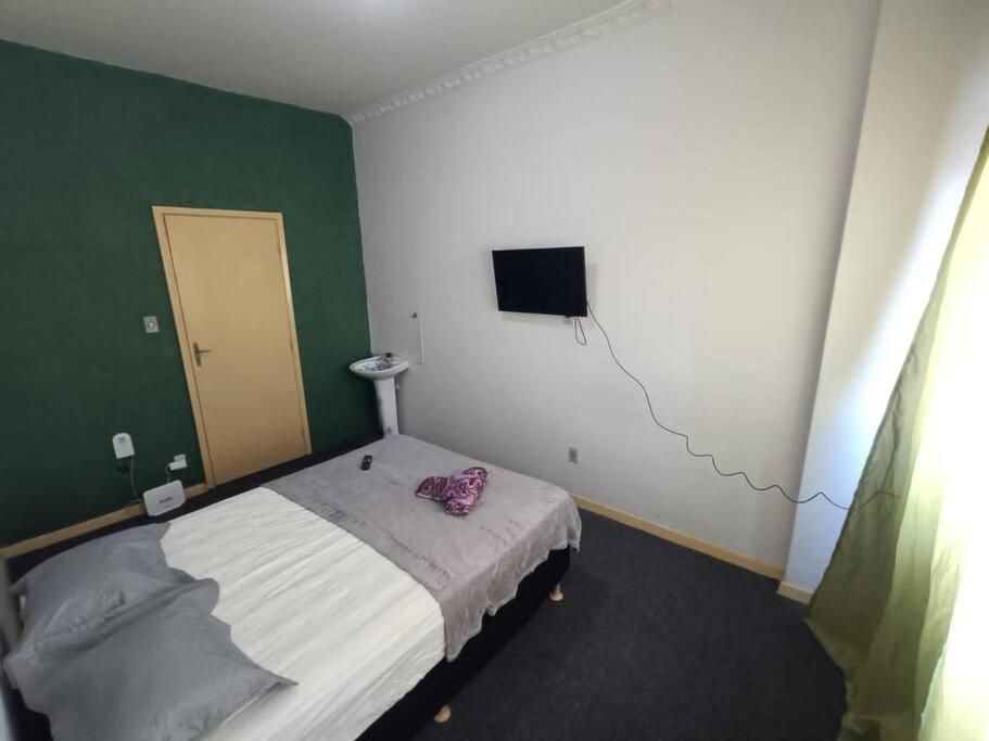 a small bedroom with a bed and a television at Studio Niterói-Barcas 604 in Niterói