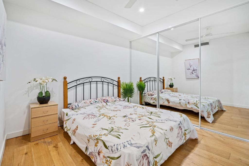 a bedroom with two beds and a mirror at Sydney Central in Sydney
