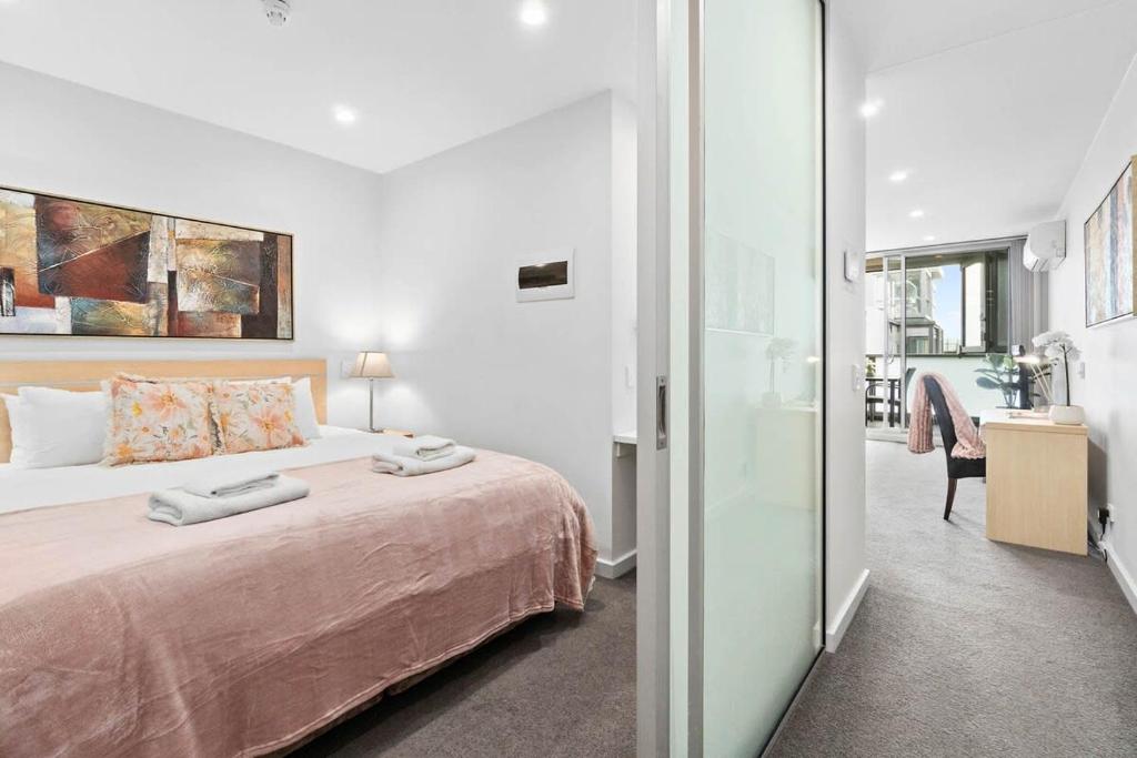 een slaapkamer met een bed en een kamer met een bureau bij The CBD Hidden Gem 1BR Central & Walkable Haven in Adelaide
