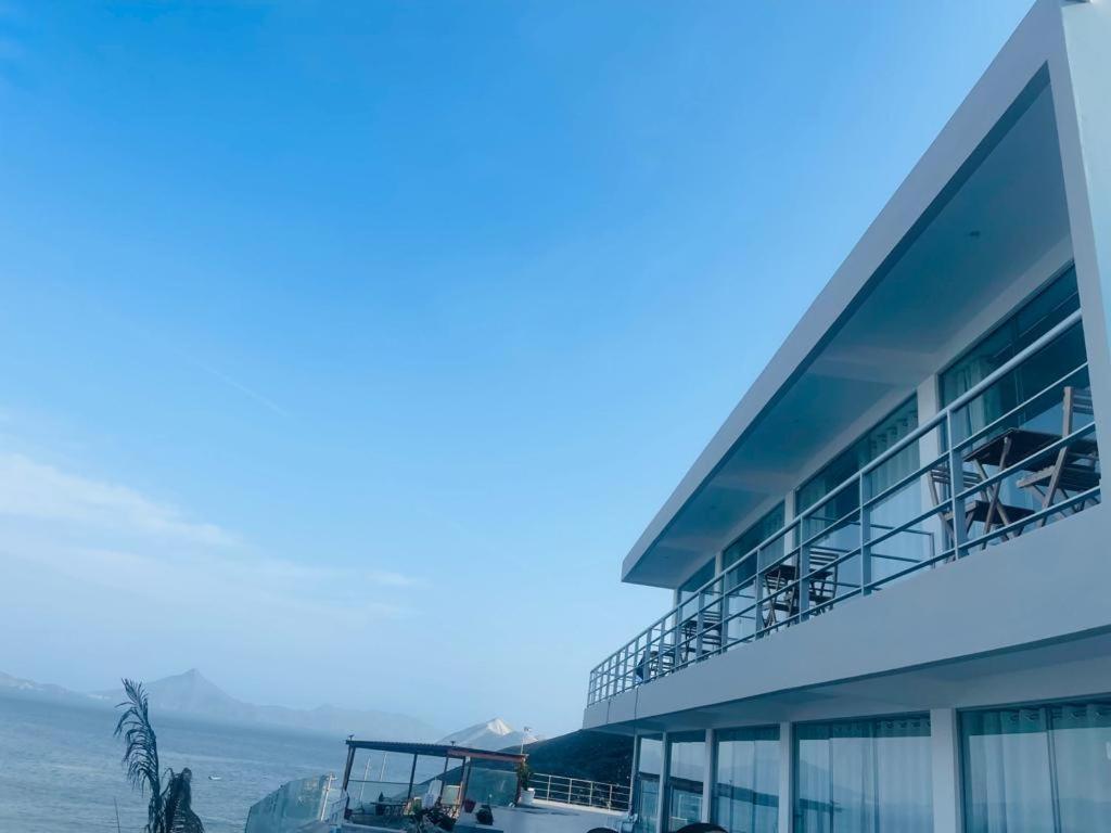 a building with a balcony with a view of the ocean at Serenity Inn Los Chimus in Tortuga