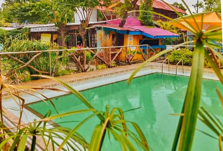 a swimming pool in front of a house at Iloilo Paraw Beach Resort in Iloilo City