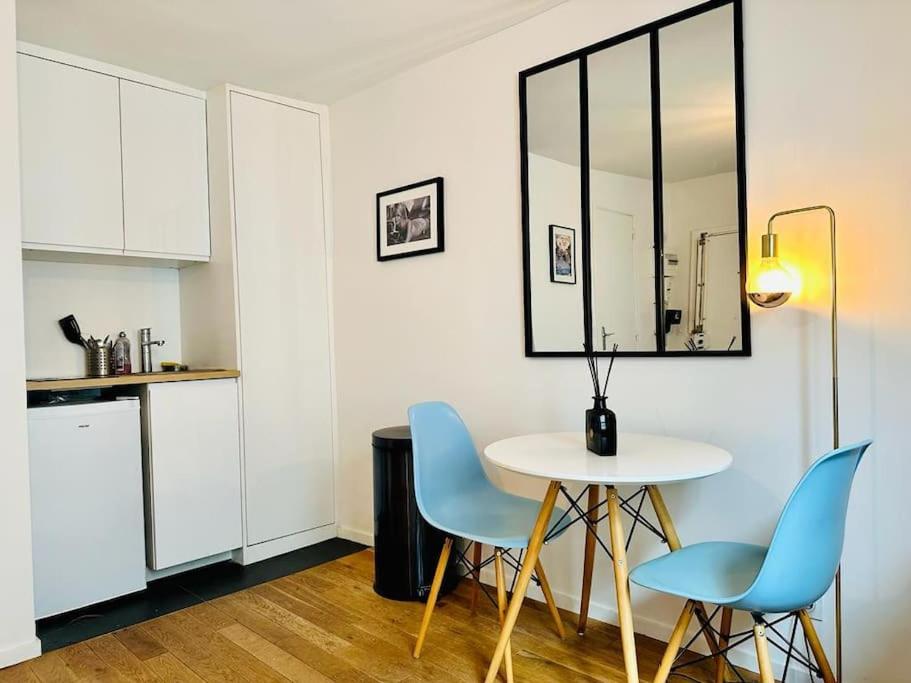 uma cozinha com uma mesa e duas cadeiras e uma mesa em Au centre de paris Saint-michel/St germain despres em Paris