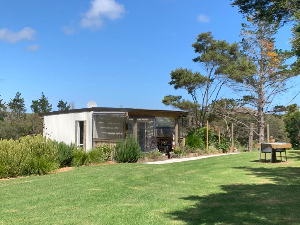 a small building with a grassy yard at The Perch in Houhora