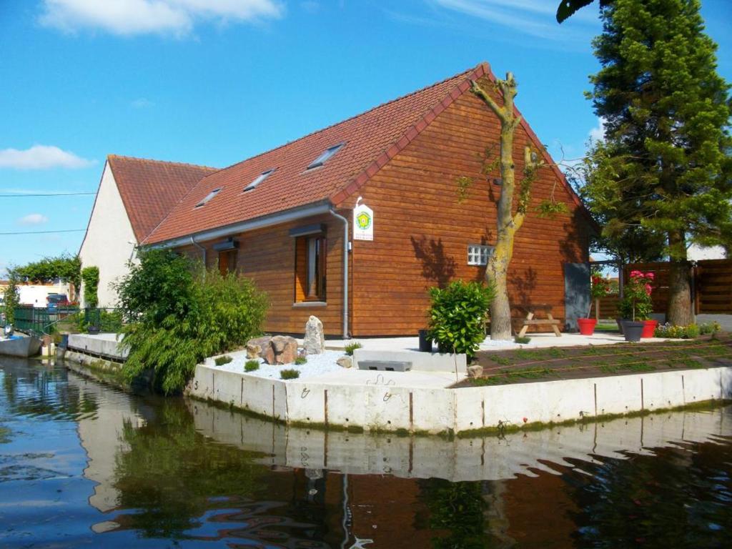 a wooden building next to a body of water at Gîte Saint-Omer, 4 pièces, 7 personnes - FR-1-376-72 in Saint-Omer