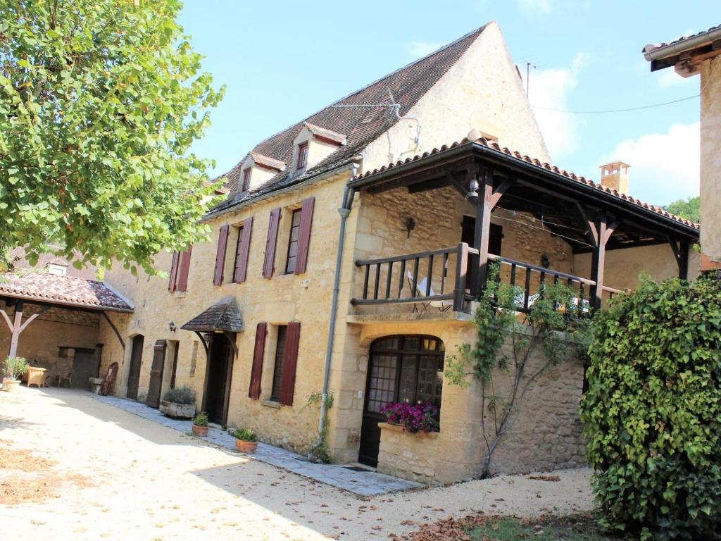 een oud stenen huis met een veranda en een balkon bij Gîte La Roque-Gageac, 3 pièces, 4 personnes - FR-1-616-136 in La Roque-Gageac