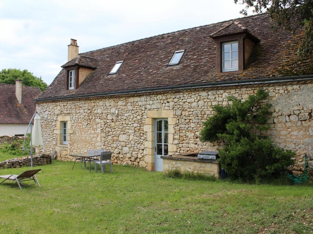 an old stone building with a table and chairs in a yard at Gîte Monsac, 4 pièces, 5 personnes - FR-1-616-103 in Monsac