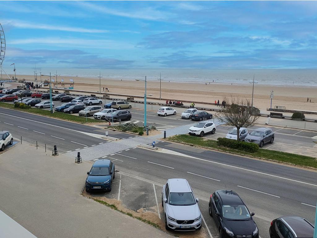 - un parking avec des voitures garées à côté de la plage dans l'établissement Appartement rénové face à la mer avec balcon - 2 chambres - Saint-Jean-de-Monts - FR-1-323-472, à Saint-Jean-de-Monts