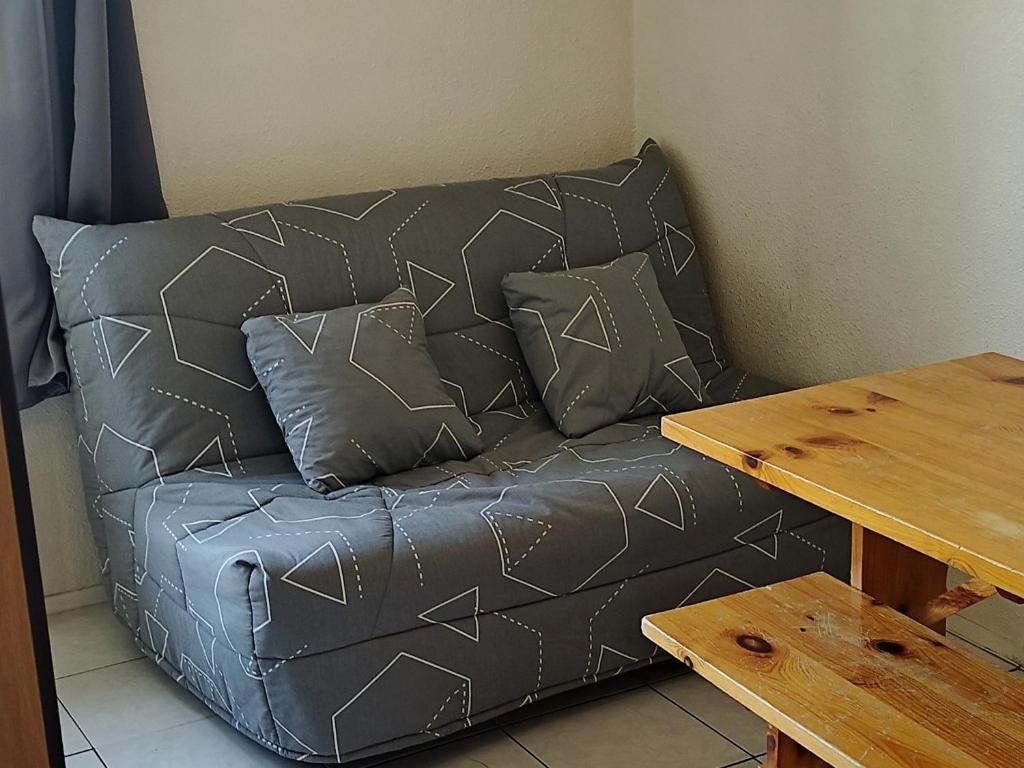 un sofá de cuero con almohadas junto a una mesa en Studio Les Adrets-Prapoutel, 1 pièce, 3 personnes - FR-1-771-3, en Les Adrets