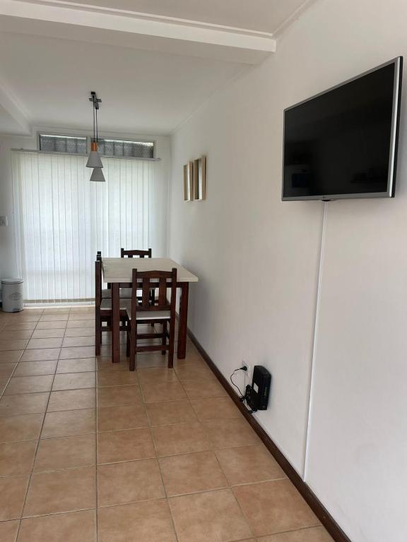 une salle à manger avec une table et une télévision murale dans l'établissement Departamento Emilia 1, à Chascomús