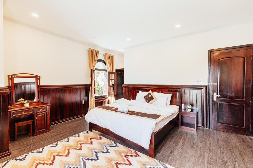 - une chambre avec un grand lit et un mobilier en bois dans l'établissement Villa Trung Nghĩa 38, à Khu Chi Lăng