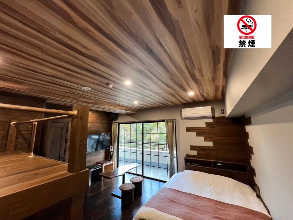 a bedroom with a bed and a wooden ceiling at Hotel 螢月ｰhozukiｰ Adult Only in Sendai