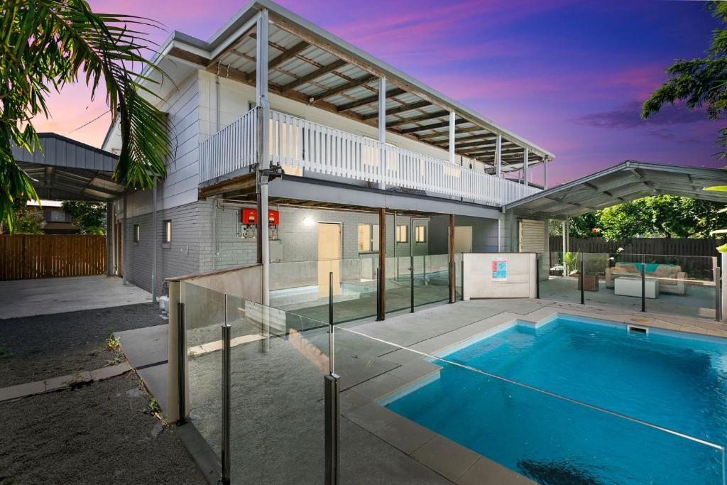 a house with a swimming pool in front of it at Unwind on Prince in Urangan
