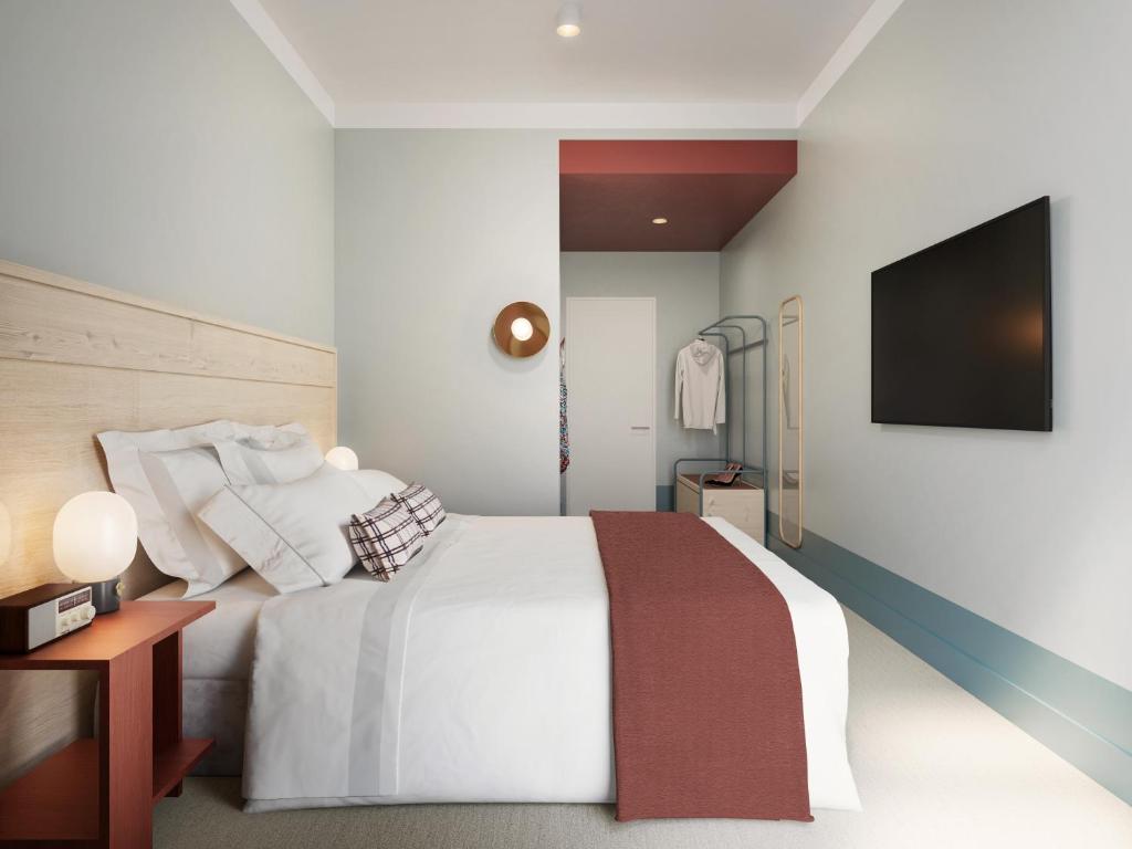 um quarto com uma cama branca e uma televisão de ecrã plano em Drifter Christchurch em Christchurch