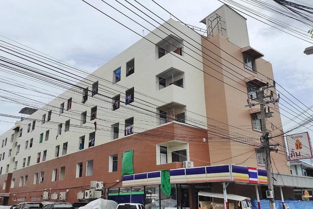 un edificio en una calle de la ciudad con líneas eléctricas en Kim Hotel At Bangplong en Ban Bang Prong