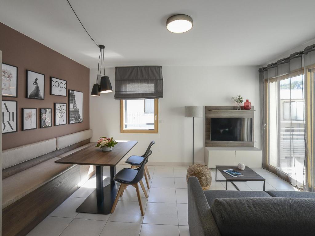 uma sala de estar com uma mesa e um sofá em Studio Aix-les-Bains, 1 pièce, 2 personnes - FR-1-617-26 em Aix-les-Bains