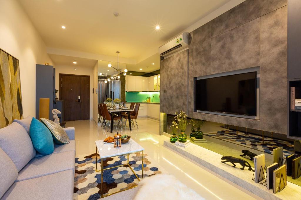 ein Wohnzimmer mit einem großen Flachbild-TV in der Unterkunft Jessie Saigon Apartment - Vinhome Central Park in Ho-Chi-Minh-Stadt