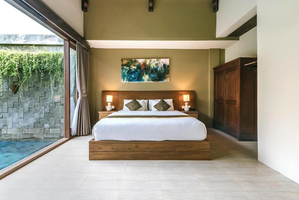 a bedroom with a large bed and a large window at ME Villas Echo Beach Canggu in Canggu