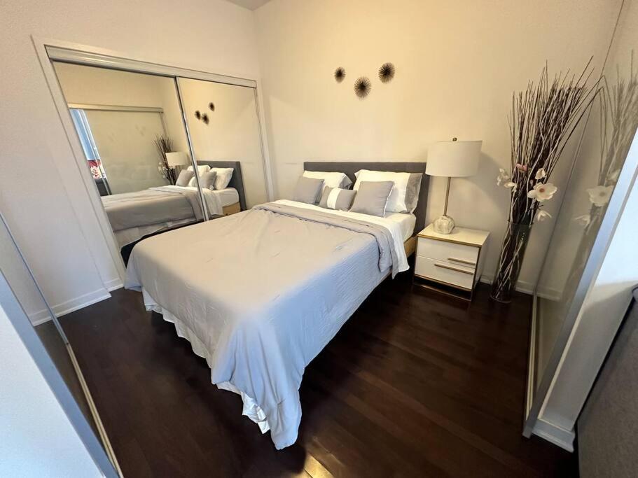 a bedroom with a large white bed and a mirror at Downtown Toronto Luxury Condo in Toronto