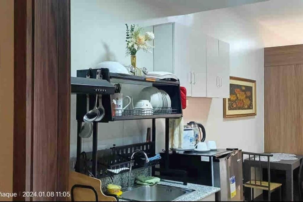 een keuken met een wastafel en een magnetron bij Doc's Place 5@ Spring Residences in Manilla