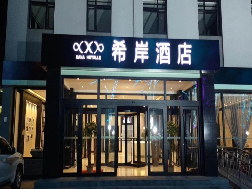a building with a sign on the front of it at Xana Hotelle·Yutian in Tangshan