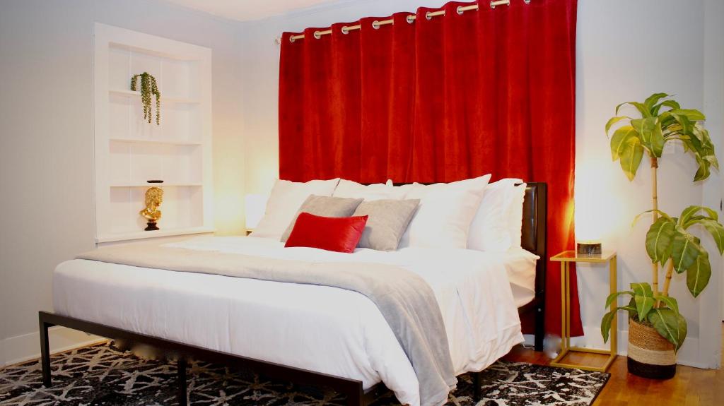 um quarto com uma cama grande e uma cortina vermelha em Cozy 2 King 2 Twin Cottage em Hattiesburg