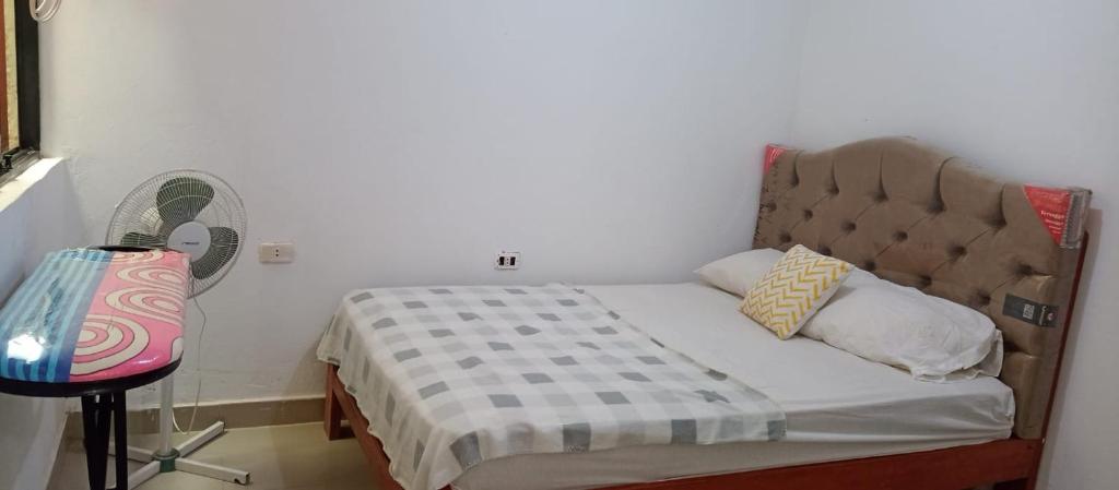 um pequeno quarto com uma cama e uma ventoinha em Mini departamento em Pucallpa