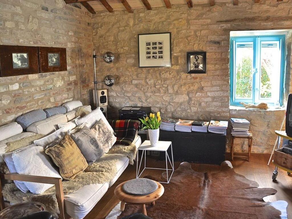 sala de estar con sofá y pared de piedra en Lovely apartment in Ripatransone AP, 