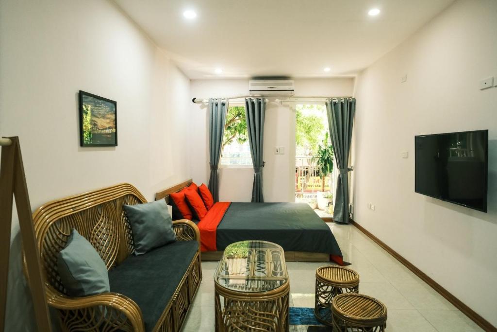 1 dormitorio con cama, sofá y TV en Central entire house in Hanoi beer street, en Hanói