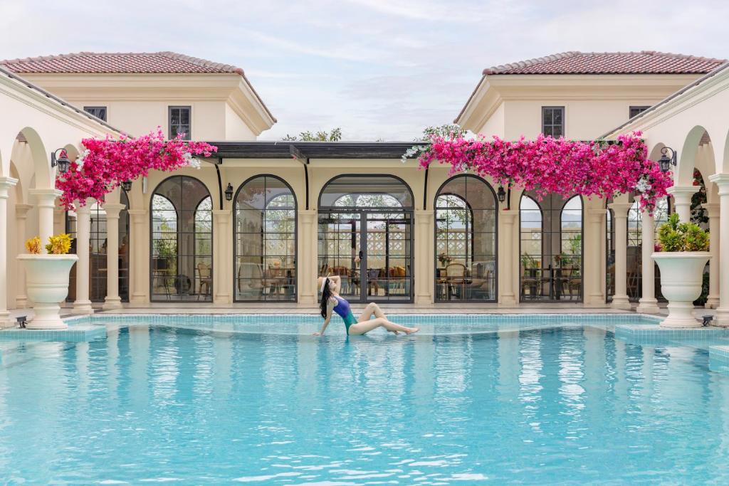 a couple playing in the water at a swimming pool at The Residence Resort & Villas Phu Quoc in Phú Quốc