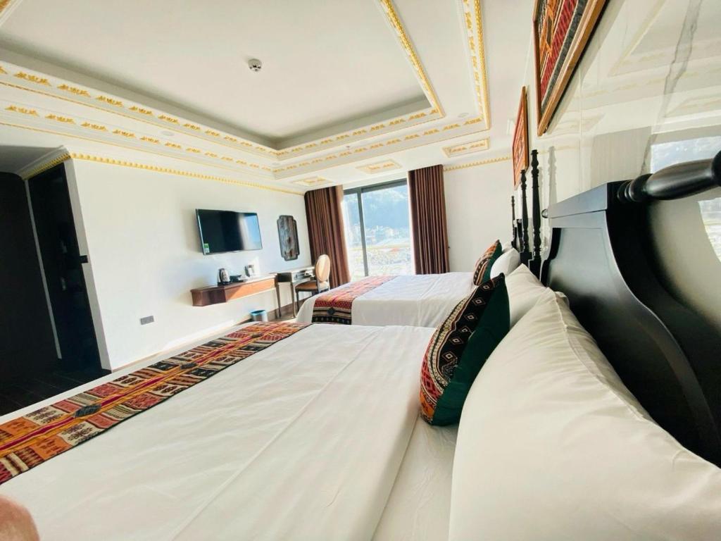 ein Hotelzimmer mit 2 Betten und einem TV in der Unterkunft Trung Huyền Hotel in Sa Pa