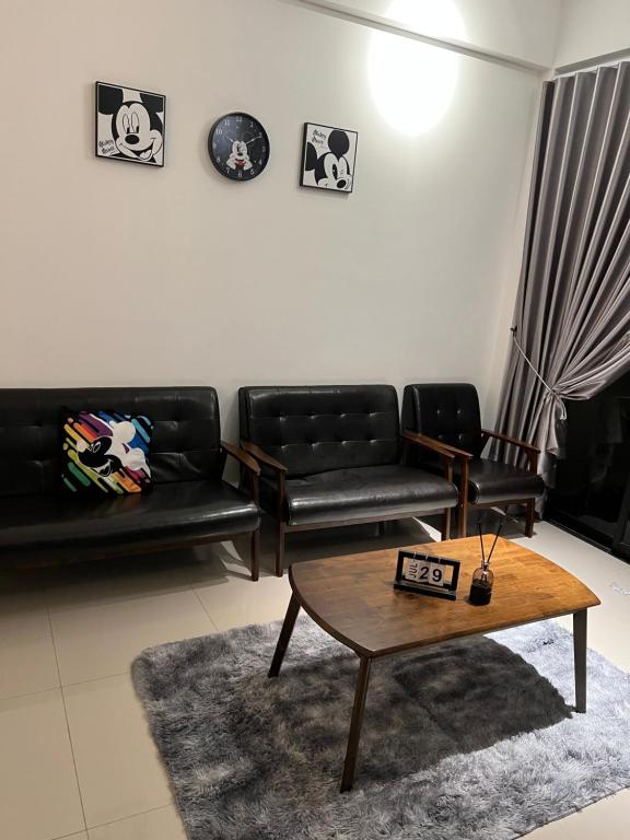 sala de estar con muebles de cuero negro y mesa de centro en Ipoh cove 米奇黑白家庭, en Ipoh